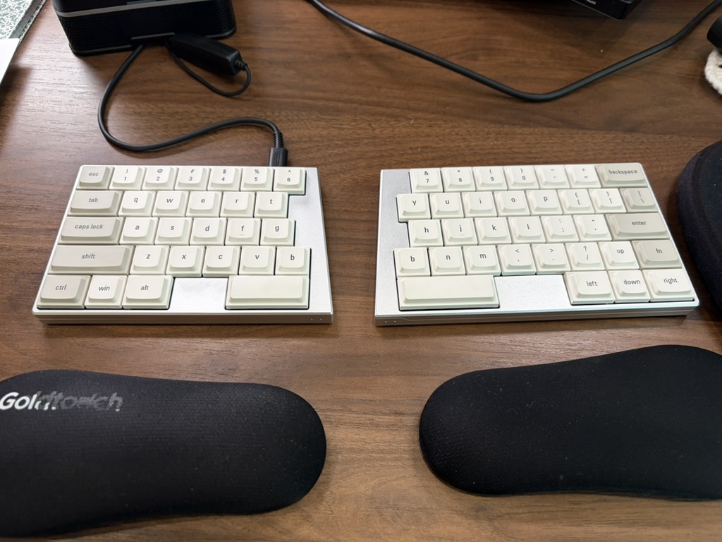 ElimKeys Elytra split low-profile mechanical keyboard in white with cream keycaps on a wooden desk