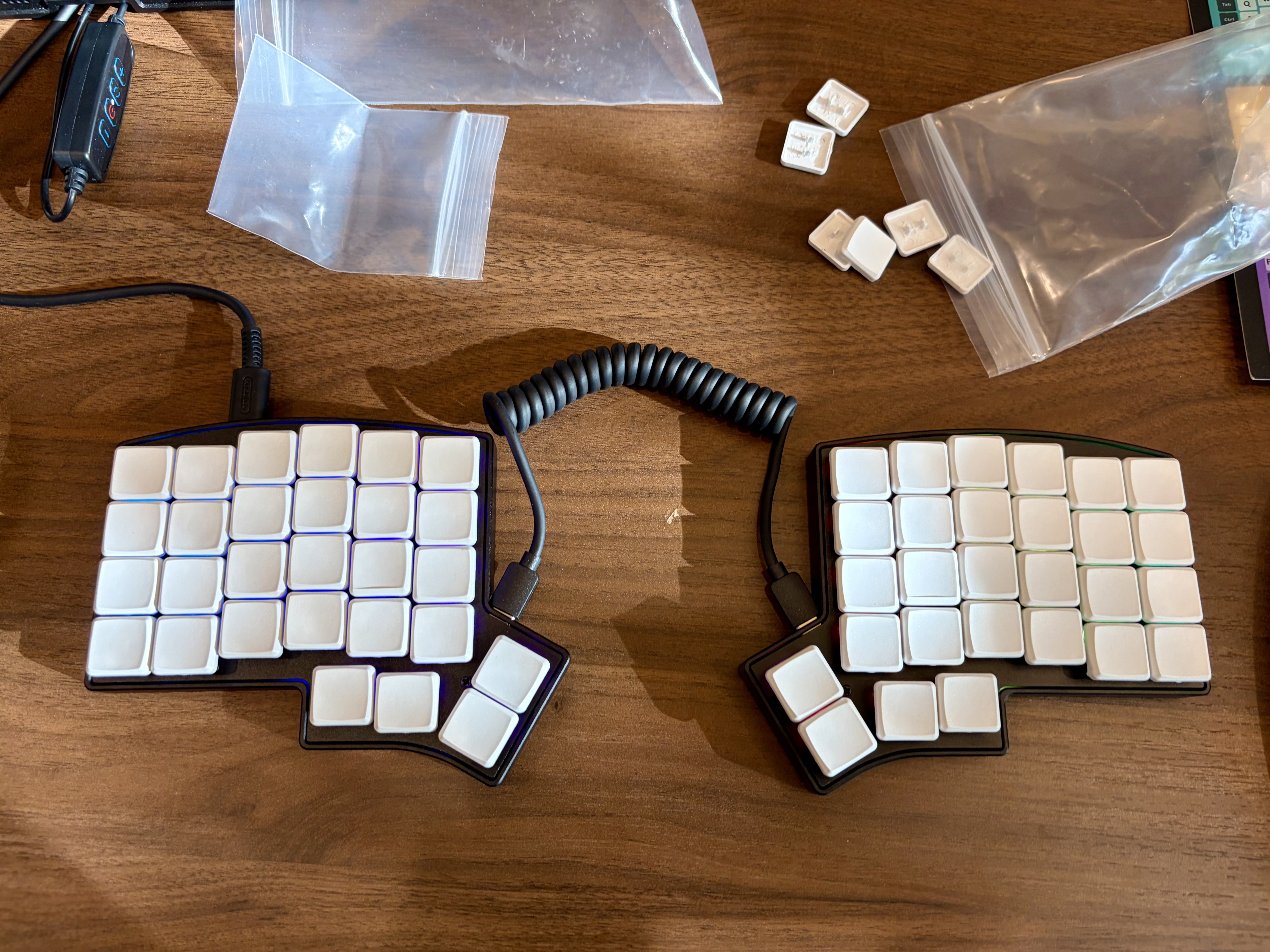 Keebio Iris CE split column-stagger keyboard with white keycaps and coiled USB-C cable, mid-keycap-swap